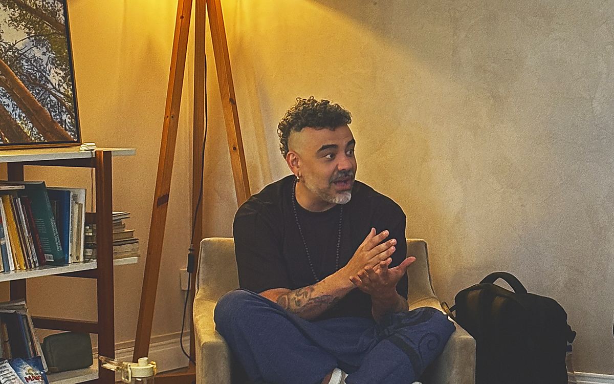 Erick Leite conduzindo uma imersão, sentado, falando com as mãos
